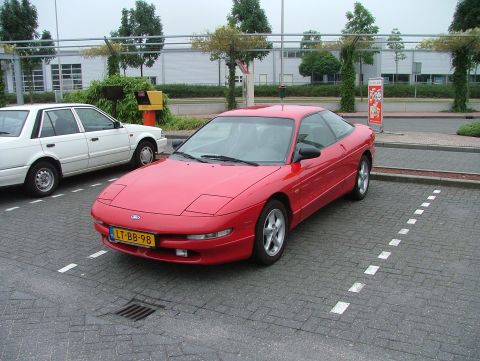 1994 Ford Probe - A red 1994 Ford Probe is parked in a lot next to a white sedan. The car has a Dutch license plate.