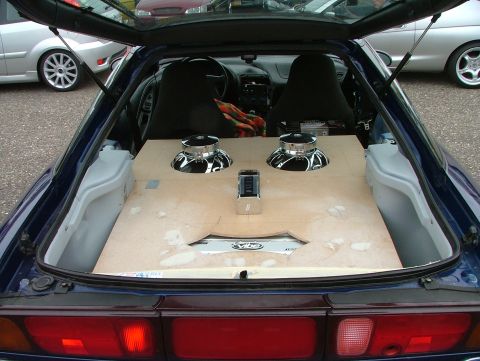 1994 Ford Probe - Custom subwoofer box installed in the trunk of a car, with other vehicles parked nearby.