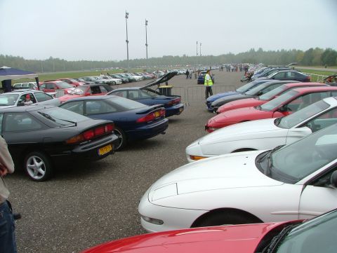1994 Ford Probe - A line of Ford Probes are parked on a cloudy day at an outdoor event.