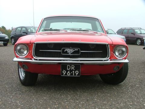 1994 Ford Probe - A classic red 1967 Ford Mustang is shown from the front, its iconic grille and horse emblem.