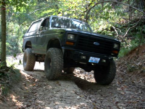 1986 Ford Bronco - This lifted 1980 Ford Bronco navigates a wooded dirt trail.