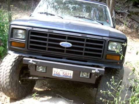 1986 Ford Bronco - Frontal view of a Ford Bronco, likely from the early 1980s, with a custom bumper and off-road tires.