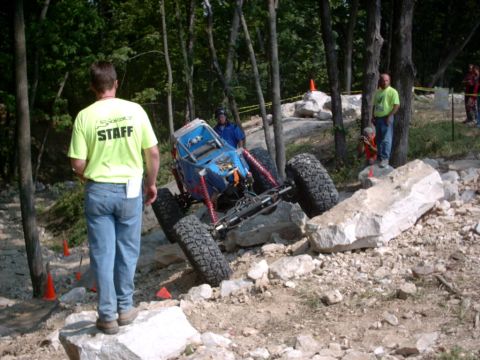 1986 Ford Bronco - A custom off-road buggy navigates a rocky obstacle course with staff members observing.