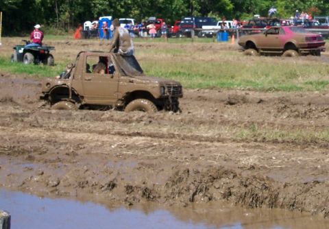 1979 Ford F-150 - Two vehicles are stuck in a mud pit during an off-road event.