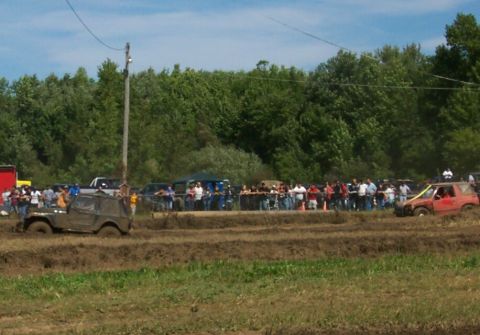 1979 Ford F-150 - Off-road vehicles participate in a mud bogging event with spectators gathered around.