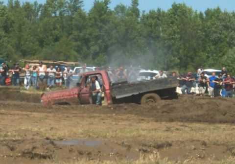 1979 Ford F-150 - Mud bogging event with a red 1979 Ford F-150 stuck in the mire.