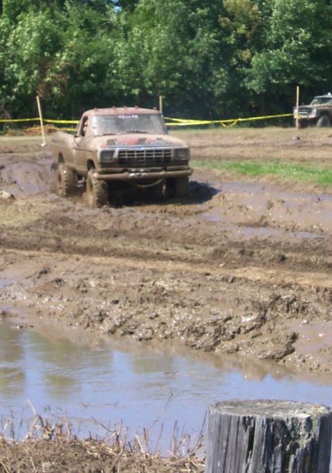 1979 Ford F-150 - This pickup truck is navigating a challenging mud course, with another vehicle in the distance.