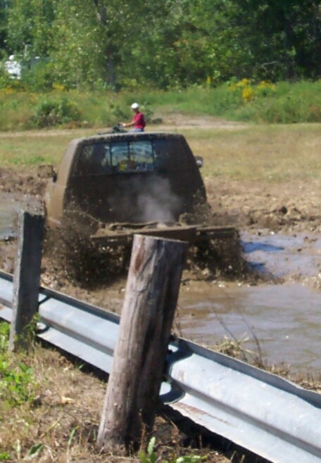 1979 Ford F-150 - A muddy 1973 Ford F-150 is stuck in a mud pit, with a person on an ATV visible behind the truck.