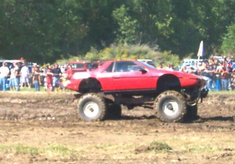 1979 Ford F-150 - Modified Pontiac Fiero with large tires in a mud bog event.