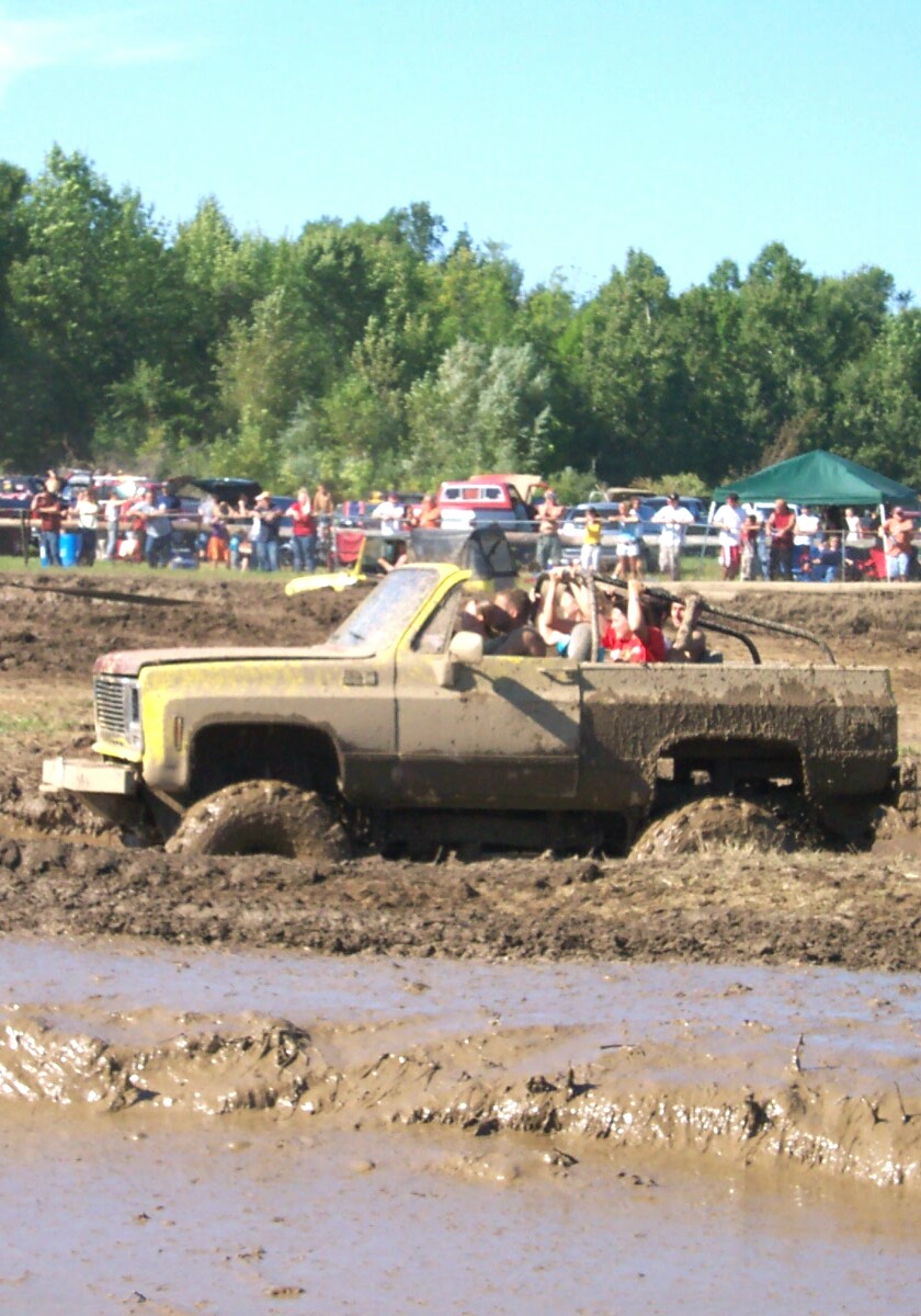 Yellow pickup truck stuck in mud pit