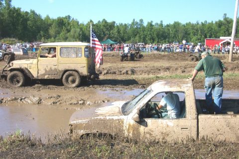 1979 Ford F-150 - Mud bogging event with multiple vehicles stuck in the mud, spectators in the background.