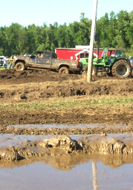 1979 Ford F-150 - Pickup truck and tractor stuck in the mud during an event.