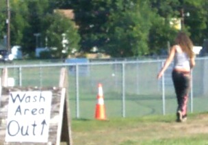1979 Ford F-150 - A woman walks past a wash area sign and a traffic cone on a sunny day.