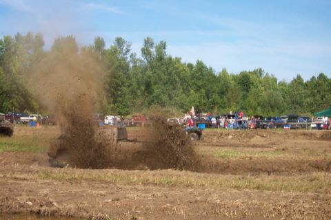 1979 Ford F-150 - A truck churns up a massive spray of mud while participating in a mud bog competition.