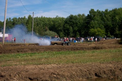 1979 Ford F-150 - A gold 1973 Ford F-150 truck emits a large cloud of smoke during an event, with spectators in the background.