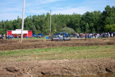 1979 Ford F-150 - Mud bog event with multiple vehicles and spectators gathered.