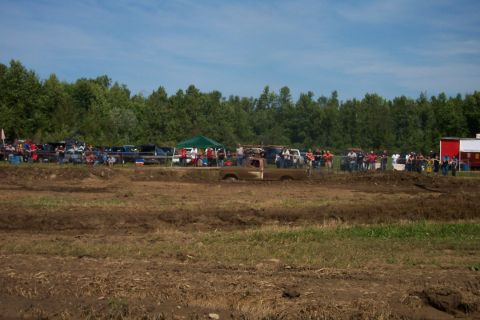 1979 Ford F-150 - A 1979 Ford F-150 navigates a muddy track during an event with spectators in the background.