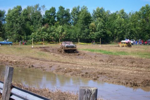 1979 Ford F-150 - A 1979 Ford F-150 navigates a muddy obstacle course with other vehicles visible.