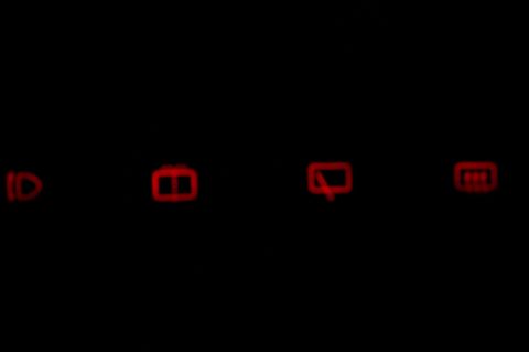 1997 Ford Probe - A close-up of illuminated dashboard warning lights against a black background.