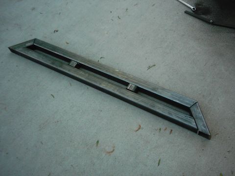1978 Ford Bronco - A fabricated metal bracket rests on a concrete surface, possibly for a vehicle project.