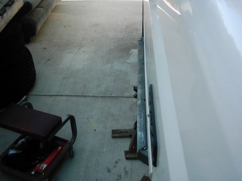 1978 Ford Bronco - Close-up of a white vehicle's side panel, showing metal trim and a portion of the body.