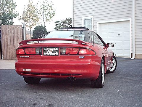 1993 Ford Probe - The rear of a red 1993 Ford Probe is visible, parked in front of a garage with the door down.