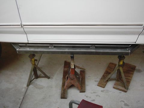 1978 Ford Bronco - Custom metal running boards are installed on a white vehicle, which is supported by jack stands.