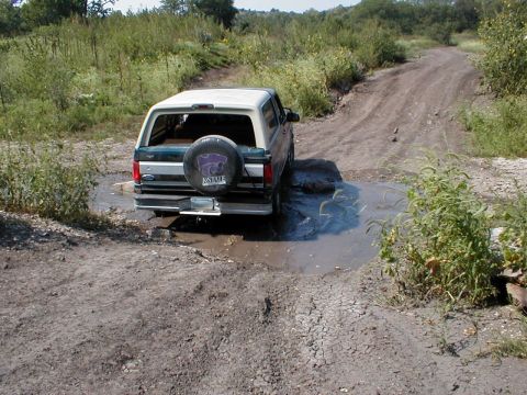 1994 Ford Bronco - This 1994 Ford Bronco navigates a muddy obstacle on an off-road trail.