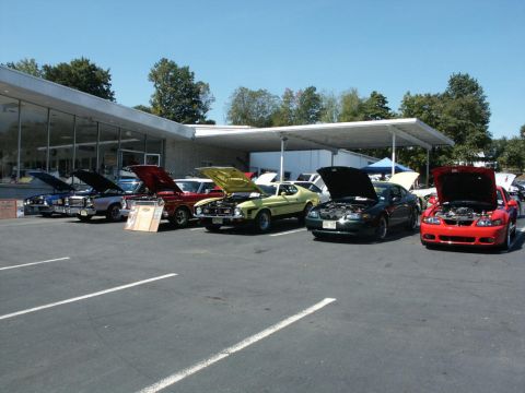 2001 Mercury Grand Marquis - A car show displays multiple vehicles with their hoods open under a covered area.