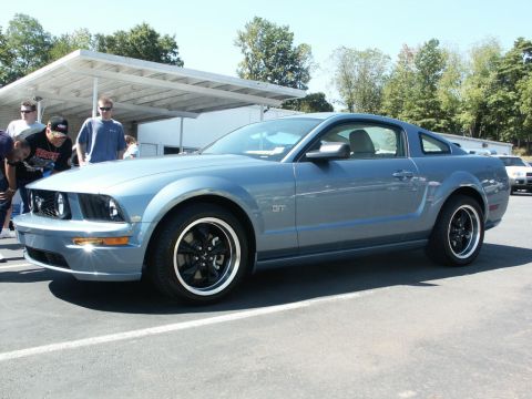 2001 Mercury Grand Marquis - A blue Ford Mustang GT is displayed at an outdoor event with several onlookers.