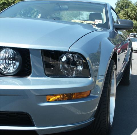 2001 Mercury Grand Marquis - A light blue 2005 Ford Mustang is seen at a car show, with other vehicles in the background.