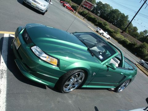 2001 Mercury Grand Marquis - A green 2001 Ford Mustang convertible is parked in a lot with other vehicles.