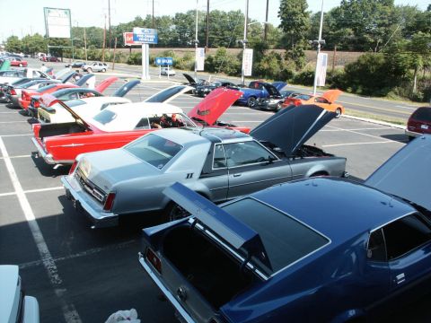 2001 Mercury Grand Marquis - A silver coupe, possibly a Lincoln Mark V, is displayed with its hood open at a car show alongside other vehicles.