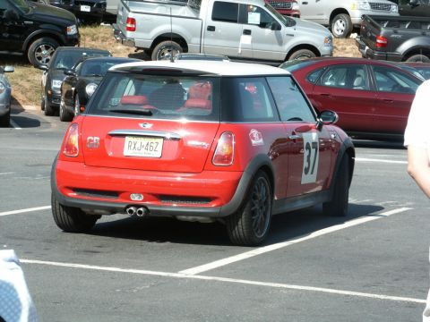 2001 Mercury Grand Marquis - A red Mini Cooper with a white roof is parked in a lot, displaying racing numbers on its side.