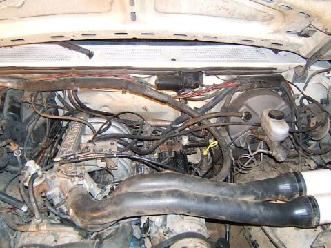 1988 Ford Bronco - Close-up view of the engine compartment, showing various hoses, wiring, and engine components.
