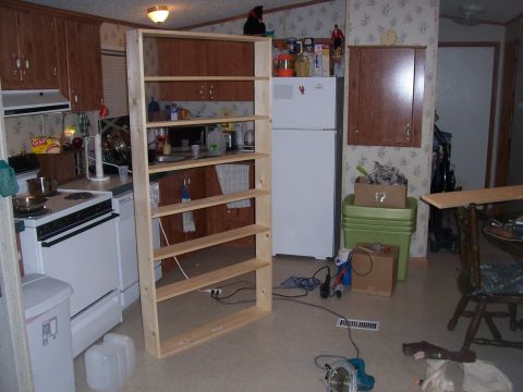 1995 Ford Bronco - A view of a room's interior, kitchen appliances and a large, unfinished wooden shelving unit.