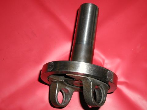 1967 Ford Ranchero - Close-up view of a metal driveshaft U-joint component, likely for a vehicle, set against a red backdrop.