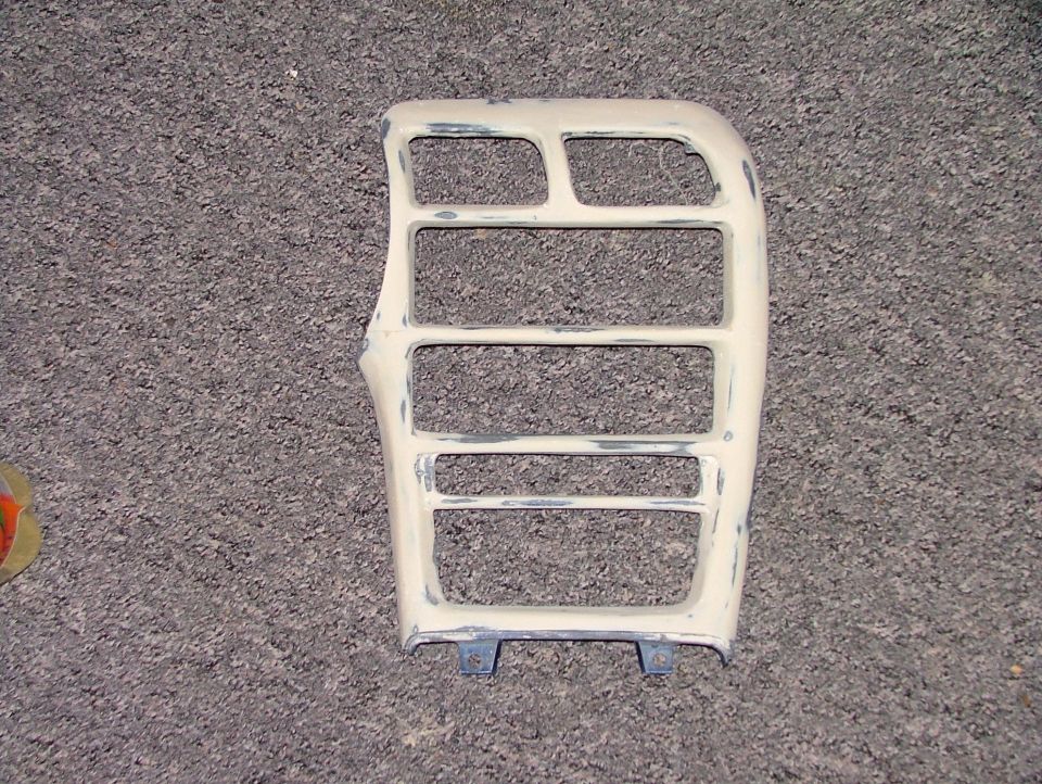 Beige car interior trim piece with multiple rectangular openings, showing signs of repair and sanding