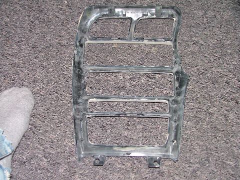 1994 Ford Probe - This is a close-up of a car's plastic grille part, shown on a carpeted floor with a foot nearby.