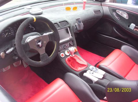 1994 Ford Probe - Interior view of a car with red seats and a custom steering wheel.