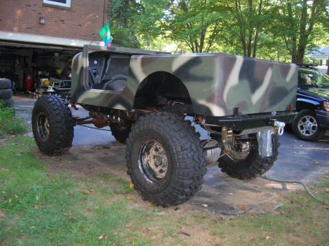 1979 Ford Bronco - This custom off-road vehicle features camouflage paint and large tires, with a winch visible at the rear.