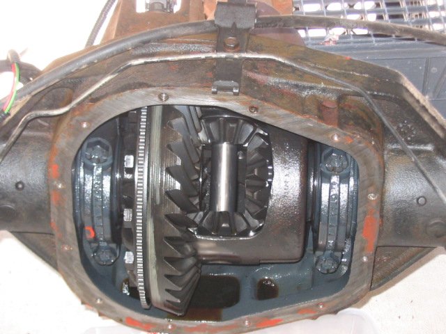 Differential housing with internal gears exposed, showing wear and oil