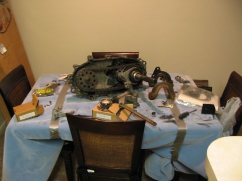 1991 Ford Bronco - Disassembled transfer case and associated parts laid out on a table for repair or maintenance.