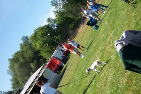 1979 Ford F-150 - An emergency vehicle is parked on a grassy field with people and a dog nearby.