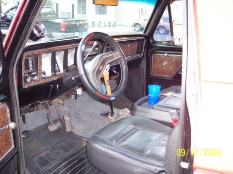 1979 Ford Bronco - Interior of a 1978 Ford F-Series truck, woodgrain trim and a blue cup.