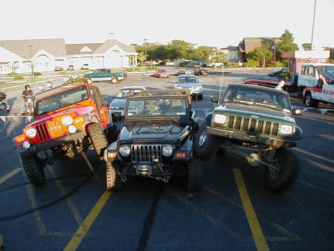 1993 Ford Bronco - Several Jeeps are parked in a lot, with a tow truck visible in the background.