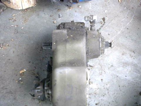 1976 Chevrolet C/K Pickup - A transfer case component is shown from an overhead perspective on a dirty concrete surface.