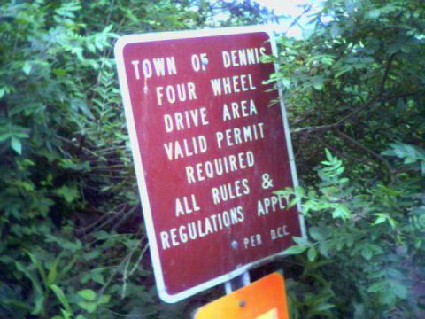 1993 Ford Bronco - A brown-and-white trailhead sign reading "Town of Dennis Four Wheel Drive Area, Valid Permit Required, All Rules & Regulations Apply, per D…