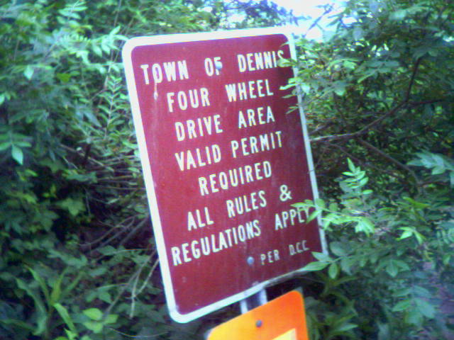 Town of Dennis four wheel drive area permit-required sign in green brush