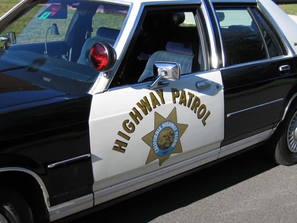 Front door of black-and-white CHP sedan with HIGHWAY PATROL star